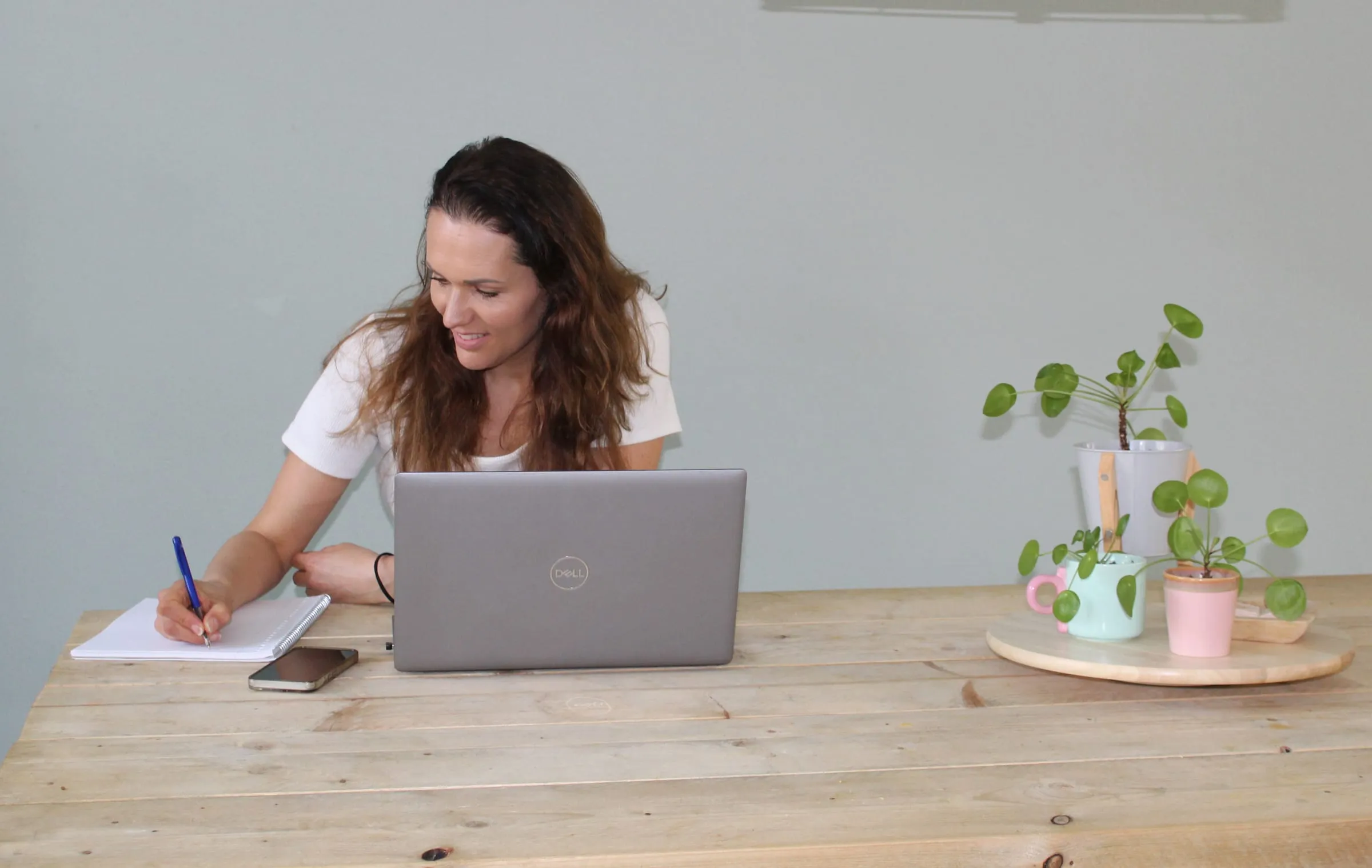 Eva achter haar laptop, aan het werk in haar praktijk